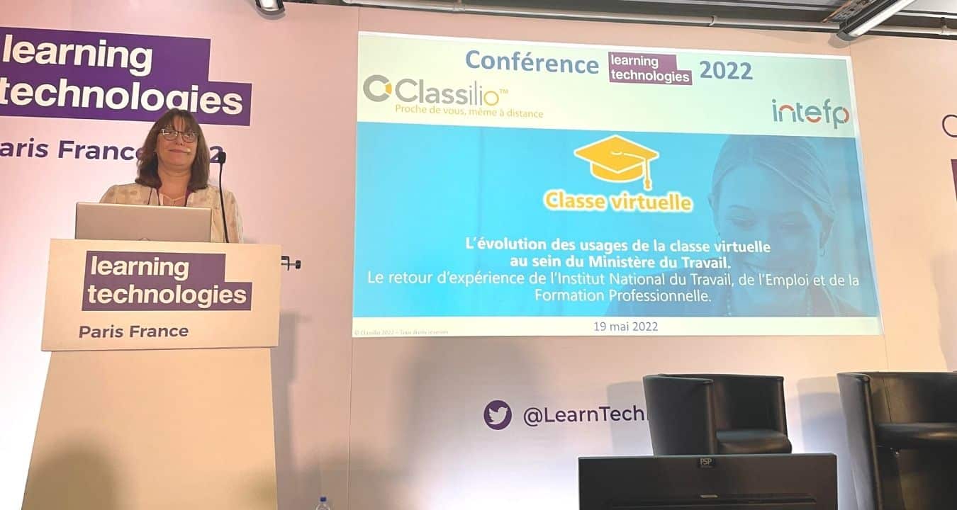conférencière devant tableau classe virtuelle