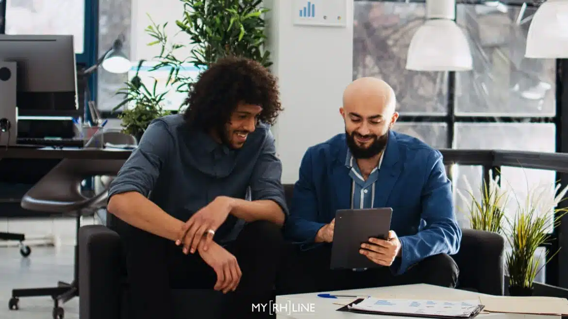 Deux collaborateurs qui utilisent un logiciel de gestion des temps sur une tablette