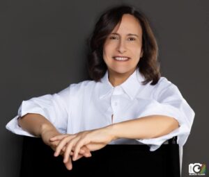 Portrait professionnel d’une femme souriante en chemise blanche, associé à l’interview de Habiba Lakhfissi sur la démarche compétences de Somfy.